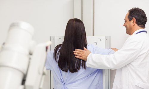 Doctor proceeding a mammography on a patient in an examination room
